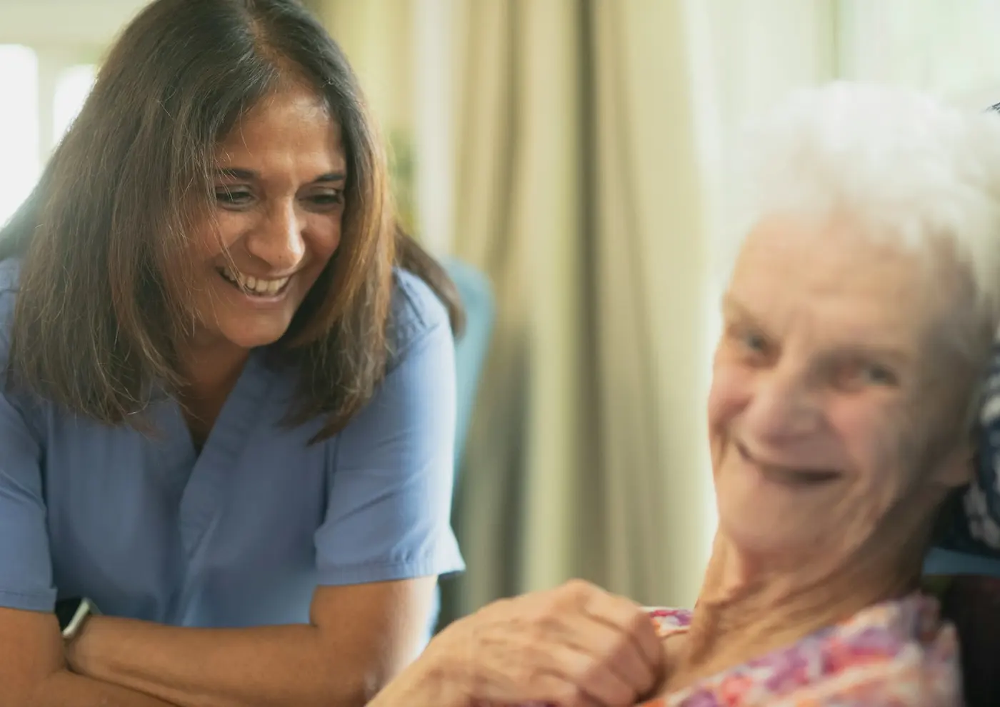 A nurse sharing a smile with an older resident